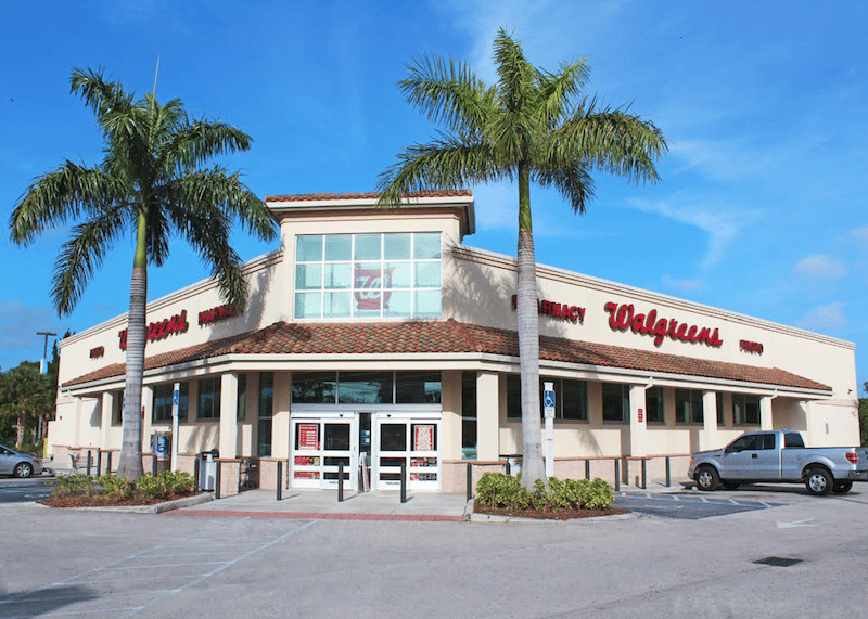 street level photo of a net lease investment property walgreens corner store with palm trees out front